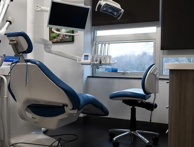 A treatment room at Westchester Dental Group, with a window and a ceiling-mounted screen.
