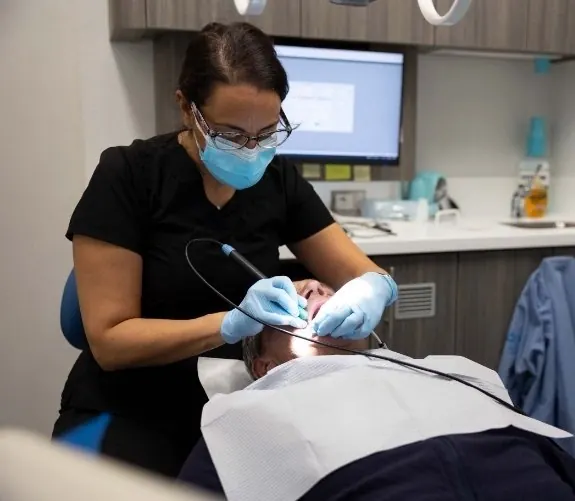 A Westchester Dental Group hygienist working on a patient's teeth.